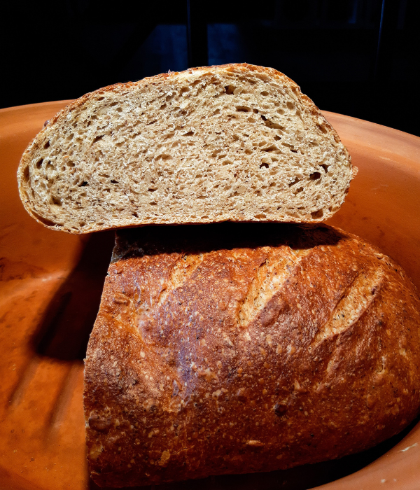 Kefir-Brot Rezept: Anschnitt eines hellen Körnerbrots im Römertopf