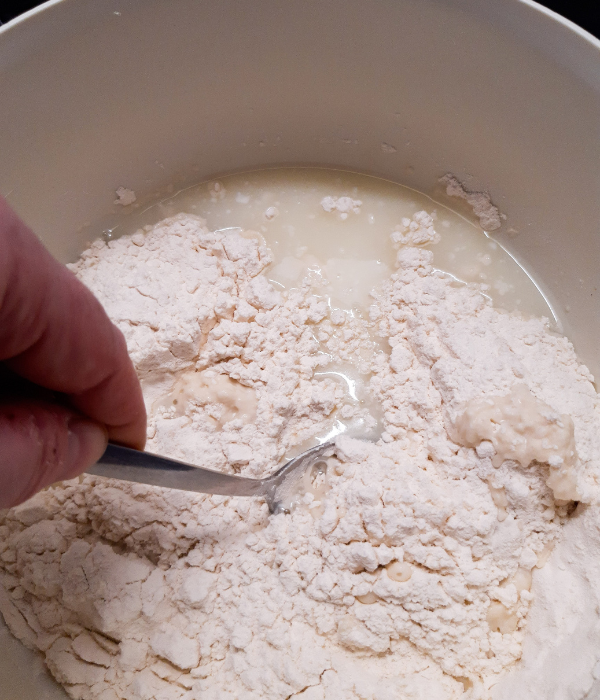 Kefir-Brot Rezept: Mehl und Molke werden mit einem Löffel kurz verrührt